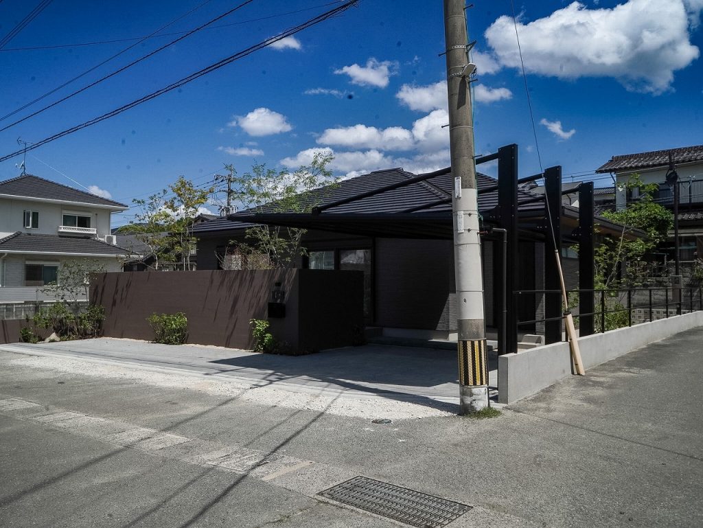 建物色に合わせた塗り壁と植栽で道路からの視線を整えた外構デザイン