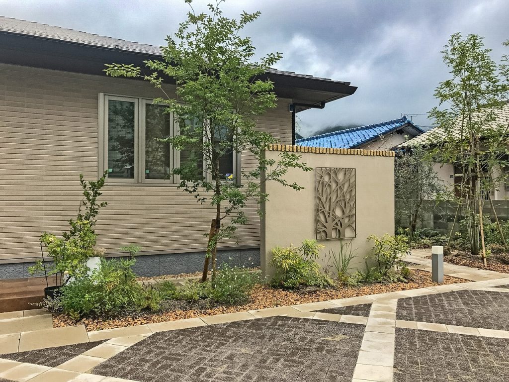 レンガと塗り壁に調和するオリーブの植栽