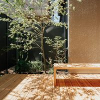 窓のすぐ外にウッドデッキと植栽を計画した庭の施工例