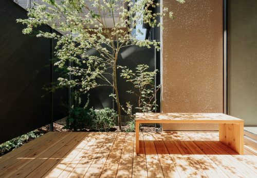 窓のすぐ外にウッドデッキと植栽を計画した庭の施工例